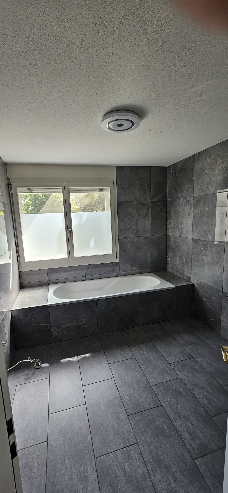 Bad mit Wanne unter Fenster, Wände in Marmoroptik
