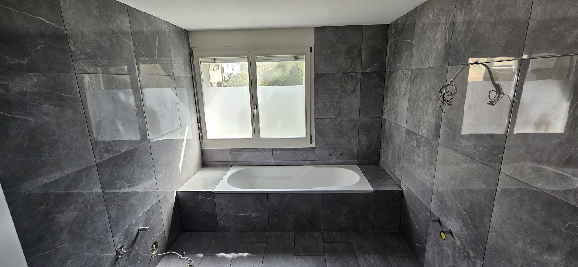 Bad mit eingefasster Badewanne und glänzenden 60×60 Platten