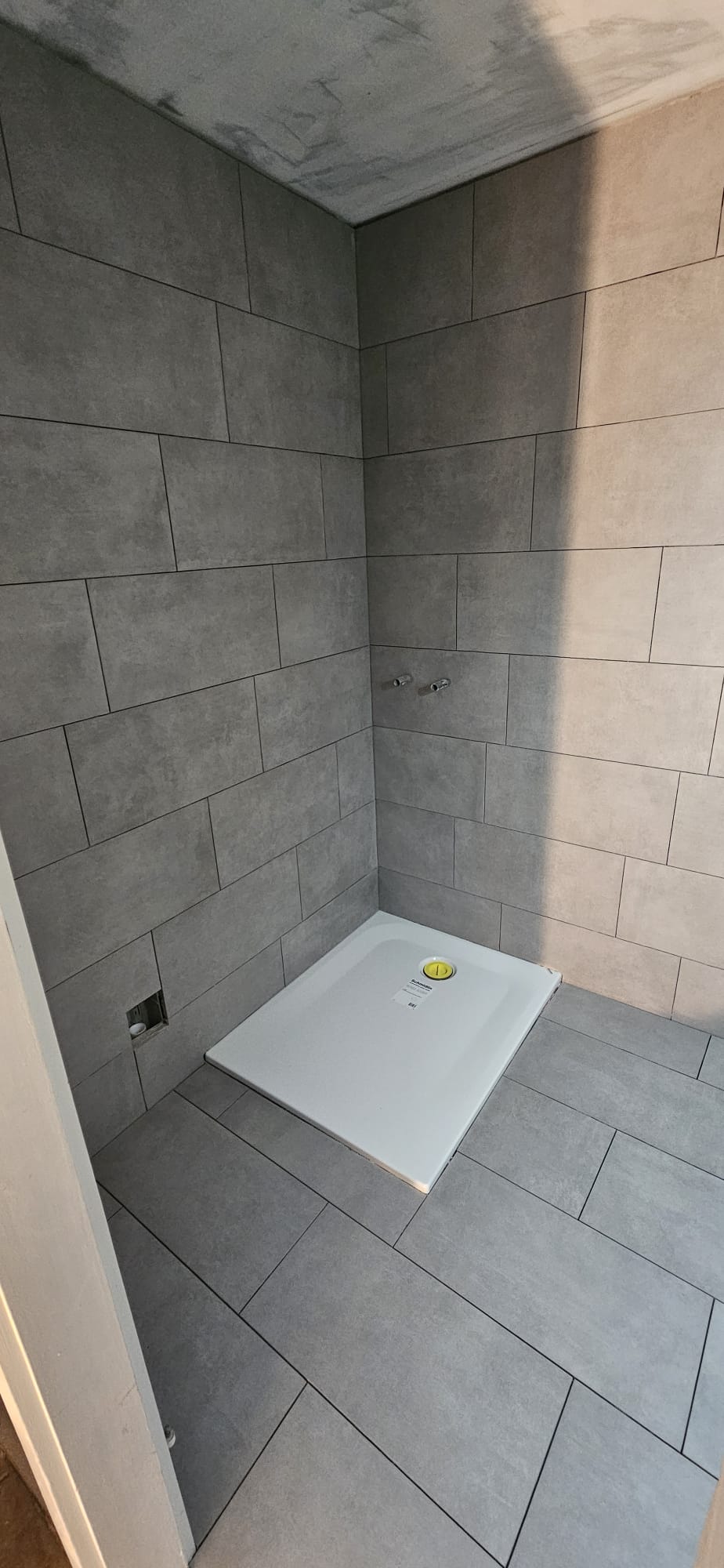 Duschbereich mit Duschwanne und 30×60 Platten in Betonoptik