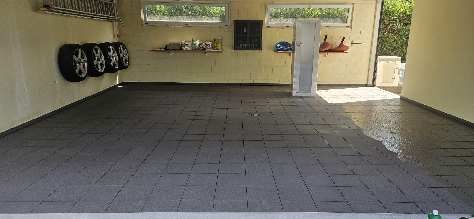 Garage mit durchgehendem Boden aus grauen 30×30 Platten